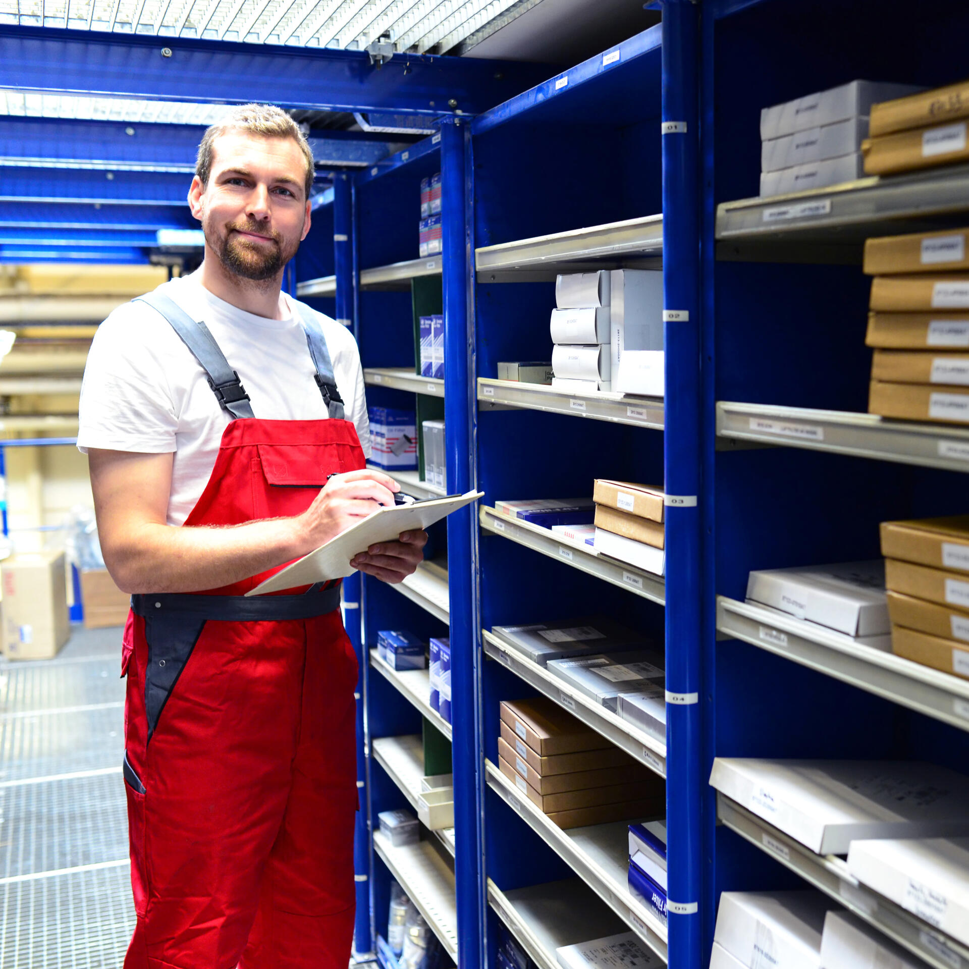 Parts specialist checking stock in the warehouse aisle
